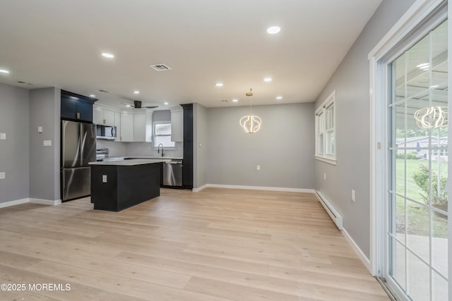 8 Phillips Rd, Brick, NJ 08724 - kitchen featuring stainless steel appliances, a baseboard heating unit, a center island, light wood-type flooring, and light countertops