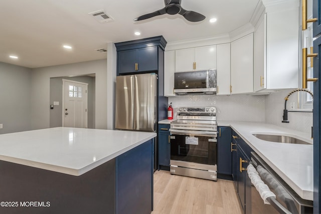 8 Phillips Rd, Brick, NJ 08724 - kitchen with appliances with stainless steel finishes, blue cabinetry, light countertops, light wood-style flooring, and white cabinetry