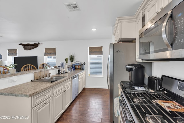 13 Locust St, Highlands, NJ 07732 - kitchen featuring appliances with stainless steel finishes, dark wood-style flooring, white cabinetry, a peninsula, and recessed lighting