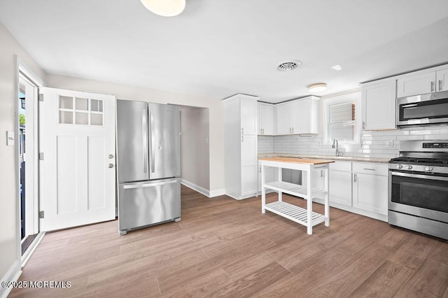 139 Seabreeze Ave, North Middletown, NJ 07748 - kitchen with stainless steel appliances, backsplash, and white cabinets