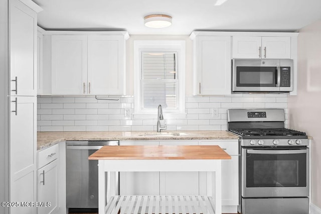 139 Seabreeze Ave, North Middletown, NJ 07748 - kitchen featuring appliances with stainless steel finishes, wooden counters, white cabinets, and tasteful backsplash