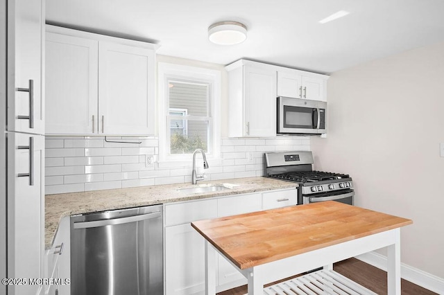 139 Seabreeze Ave, North Middletown, NJ 07748 - kitchen featuring appliances with stainless steel finishes, tasteful backsplash, white cabinetry, and light stone counters