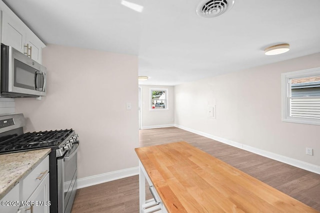 139 Seabreeze Ave, North Middletown, NJ 07748 - kitchen with appliances with stainless steel finishes, wood finished floors, and white cabinetry