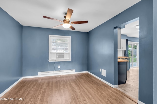 301 6th St, Waretown, NJ 08758 - spare room with a baseboard heating unit, ceiling fan, and wood finished floors