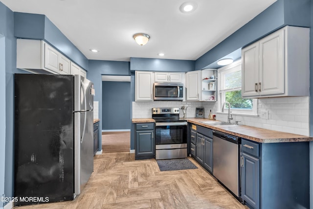 301 6th St, Waretown, NJ 08758 - kitchen with appliances with stainless steel finishes, blue cabinetry, white cabinetry, backsplash, and recessed lighting