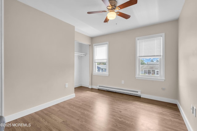 301 6th St, Waretown, NJ 08758 - unfurnished bedroom with a baseboard radiator, multiple windows, wood finished floors, and a closet