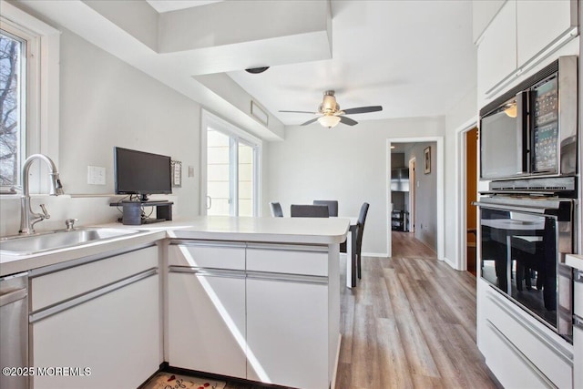 23 Clinton Dr, Manalapan, NJ 07726 - kitchen with black oven, dishwasher, a peninsula, white cabinets, and a ceiling fan