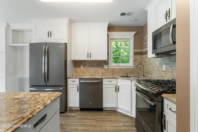 31 Strawberry Ln, Lakewood, NJ 08701 - kitchen featuring appliances with stainless steel finishes, white cabinetry, dark wood-style flooring, and light stone counters