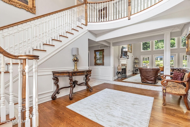 9 Withers Ln, Atlantic Highlands, NJ 07716 - staircase with a towering ceiling, wood finished floors, a fireplace with flush hearth, a decorative wall, and a wainscoted wall