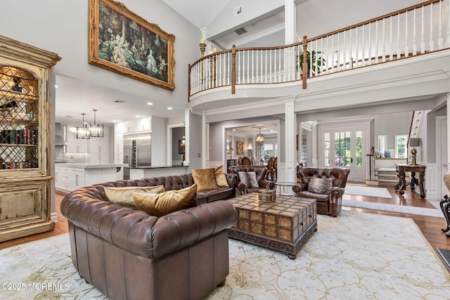 9 Withers Ln, Atlantic Highlands, NJ 07716 - living room with light wood-type flooring, high vaulted ceiling, decorative columns, and a chandelier
