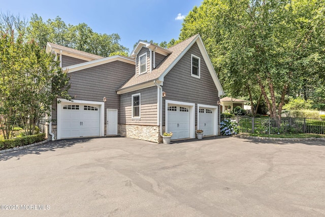 9 Withers Ln, Atlantic Highlands, NJ 07716 - view of home's exterior with stone siding, roof with shingles, asphalt driveway, and an attached garage