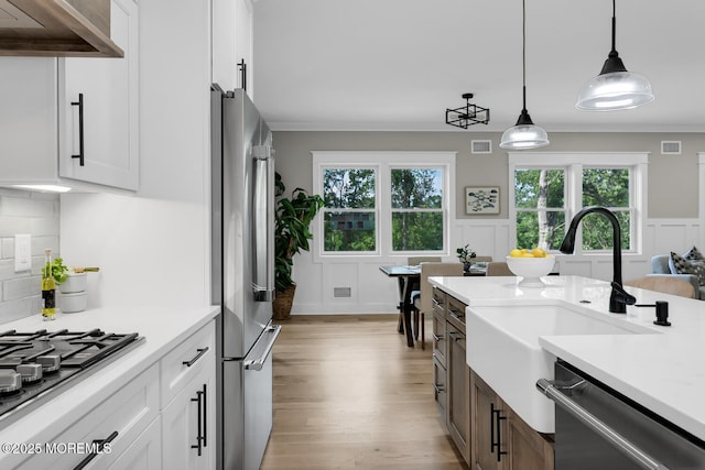 515 Atlantic Ave, Middletown, NJ 07748 - kitchen with appliances with stainless steel finishes, exhaust hood, light countertops, light wood-style flooring, and a decorative wall