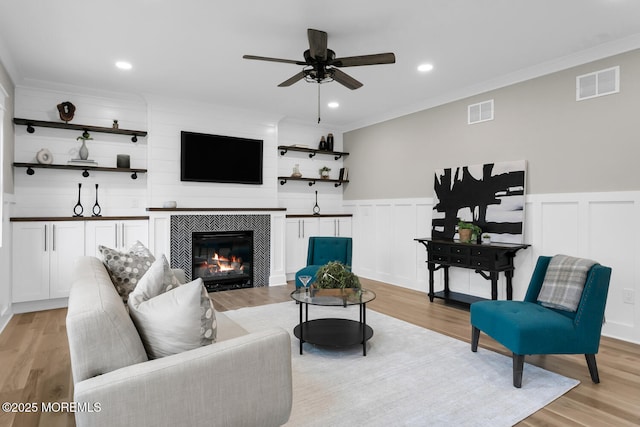 515 Atlantic Ave, Middletown, NJ 07748 - living room featuring a ceiling fan, a tile fireplace, light wood-style flooring, ornamental molding, and a decorative wall