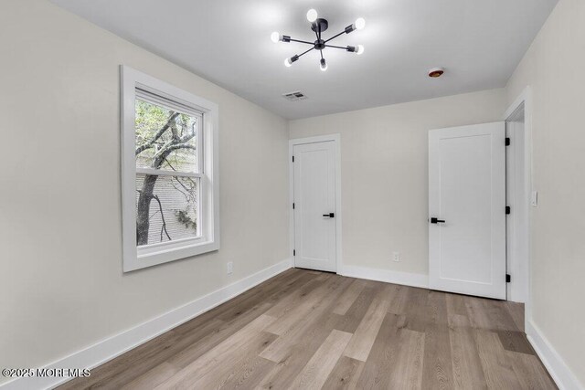 420 Philadelphia Ave, Egg Harbor City, NJ 08215 - unfurnished bedroom with a chandelier and light wood-style flooring