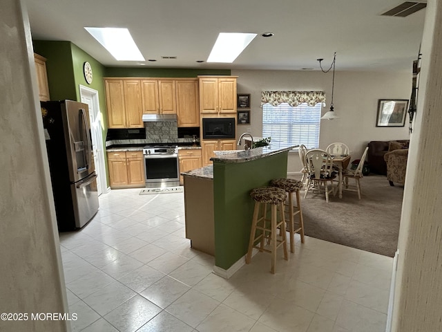 7 Fontaine Ct, Manchester, NJ 08759 - kitchen featuring appliances with stainless steel finishes, a skylight, under cabinet range hood, a breakfast bar, and tasteful backsplash