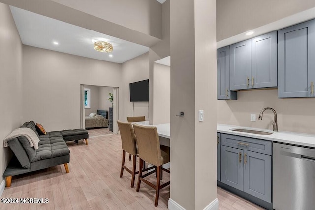 321 6th Ave Unit 103, Asbury Park, NJ 07712 - kitchen featuring stainless steel dishwasher, light countertops, light wood-style floors, open floor plan, and gray cabinetry