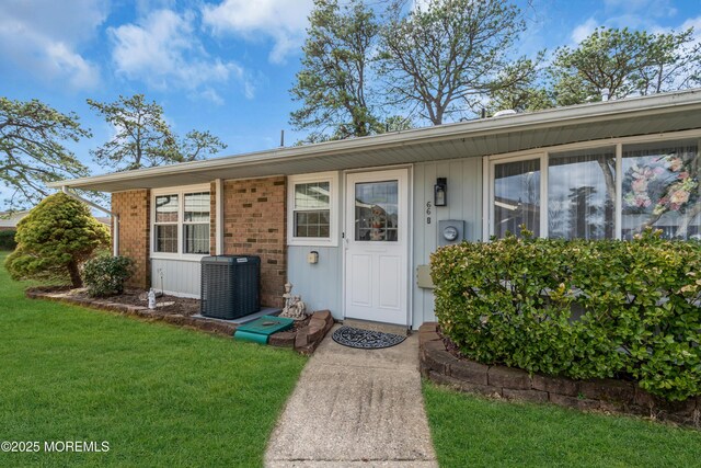 66B Buckingham Dr, Manchester, NJ 08759 - view of exterior entry with a lawn and brick siding