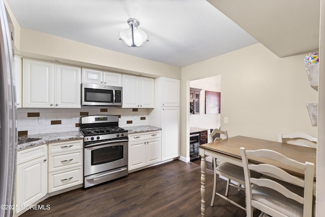 48 Carmel Ct, Old Bridge, NJ 08857 - kitchen with stainless steel appliances, backsplash, dark wood finished floors, white cabinetry, and light stone countertops