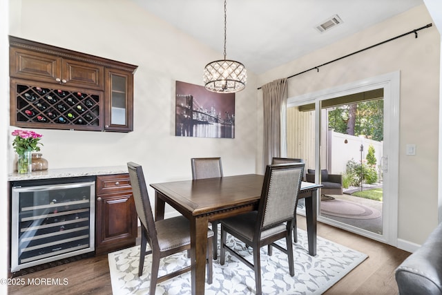 48 Carmel Ct, Old Bridge, NJ 08857 - dining room featuring wine cooler, a bar, a chandelier, dark wood-style floors, and lofted ceiling