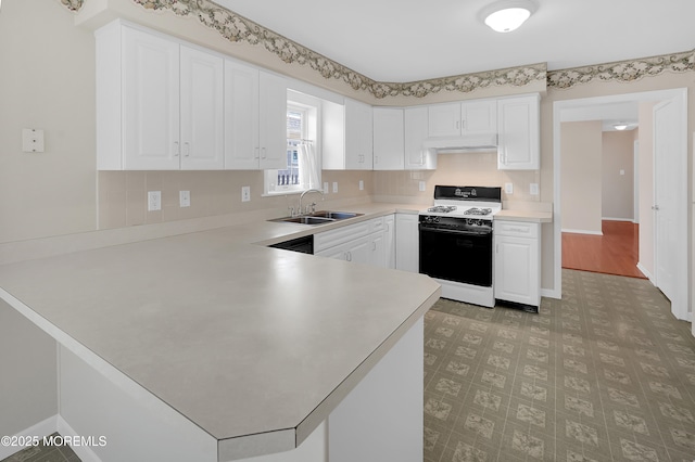 305 11th Ave, Spring Lake Heights, NJ 07762 - kitchen with white gas range oven, under cabinet range hood, a peninsula, light countertops, and white cabinetry