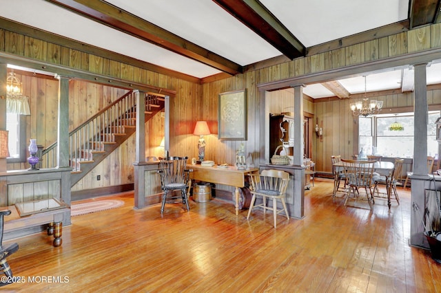 18 Holly St, Rumson, NJ 07760 - living area featuring decorative columns, wood walls, beamed ceiling, a chandelier, and stairs