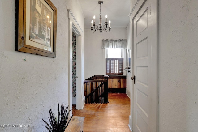18 Holly St, Rumson, NJ 07760 - hallway with a chandelier, light wood-style flooring, a textured wall, and an upstairs landing