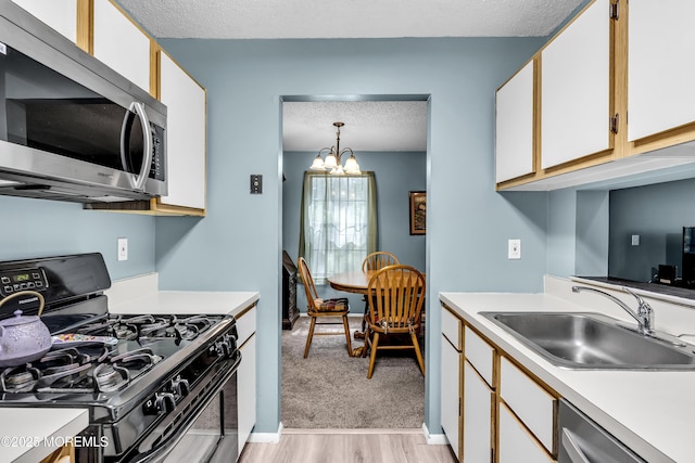 1002 Morning Glory Ct, Jackson, NJ 08527 - kitchen featuring appliances with stainless steel finishes, light countertops, light wood-style floors, a chandelier, and white cabinetry