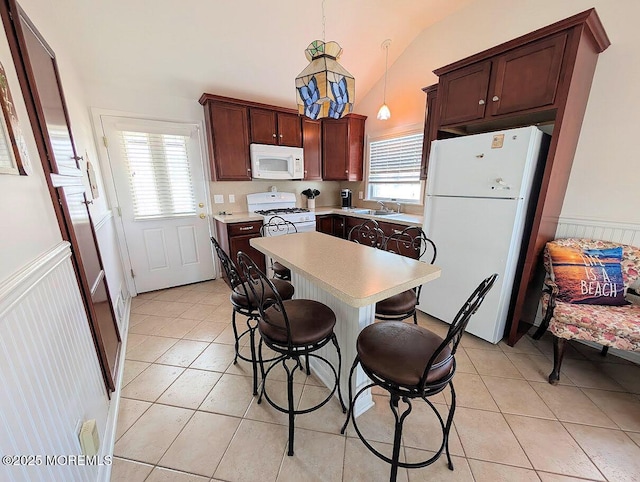 215 Harbor Dr, Lavallette, NJ 08735 - kitchen featuring white appliances, light countertops, a wainscoted wall, light tile patterned floors, and a kitchen breakfast bar