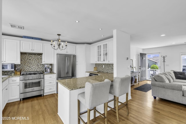 813 Tiller Dr, Forked River, NJ 08731 - kitchen with appliances with stainless steel finishes, open floor plan, a chandelier, glass insert cabinets, and white cabinets