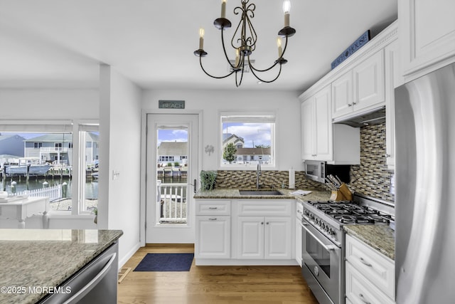 813 Tiller Dr, Forked River, NJ 08731 - kitchen featuring stainless steel appliances, white cabinets, decorative backsplash, a chandelier, and light stone countertops