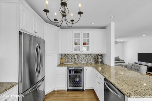 813 Tiller Dr, Forked River, NJ 08731 - kitchen with appliances with stainless steel finishes, wine cooler, white cabinetry, a peninsula, and glass insert cabinets