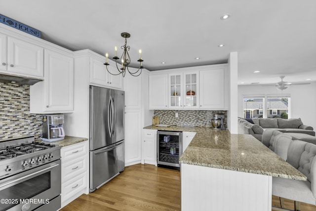 813 Tiller Dr, Forked River, NJ 08731 - kitchen featuring appliances with stainless steel finishes, wine cooler, a peninsula, a breakfast bar, and white cabinetry