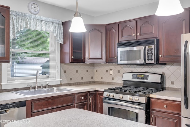 648 E Bayview Ave, Ocean Gate, NJ 08740 - kitchen featuring stainless steel appliances, light countertops, decorative light fixtures, backsplash, and glass insert cabinets
