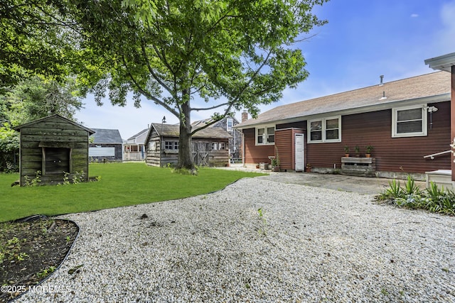 648 E Bayview Ave, Ocean Gate, NJ 08740 - rear view of house featuring a yard, a chimney, and an outdoor structure