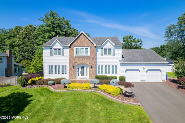 18 Rowena Rd, Manalapan, NJ 07726 - colonial-style house with an attached garage, driveway, and a shingled roof