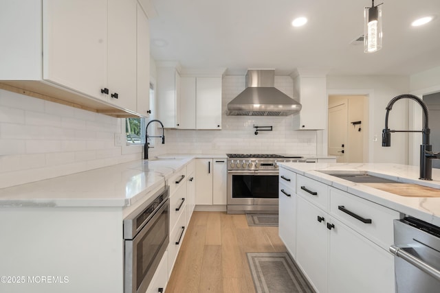 18 Rowena Rd, Manalapan, NJ 07726 - kitchen featuring wall chimney range hood, stainless steel appliances, decorative backsplash, white cabinets, and recessed lighting