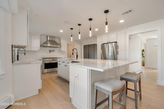 18 Rowena Rd, Manalapan, NJ 07726 - kitchen featuring stainless steel appliances, wall chimney range hood, decorative backsplash, white cabinetry, and light wood-style floors