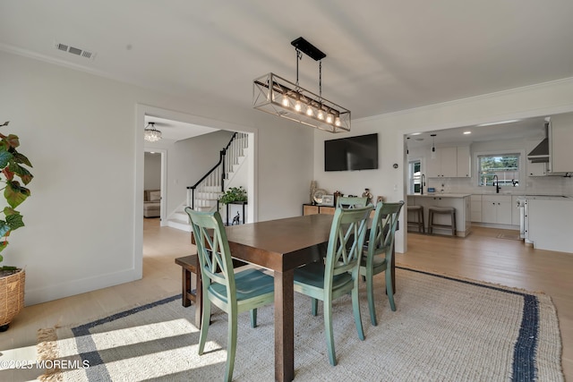 18 Rowena Rd, Manalapan, NJ 07726 - dining space featuring stairway, light wood-style flooring, and crown molding