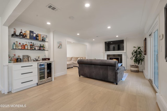 18 Rowena Rd, Manalapan, NJ 07726 - living area with beverage cooler, a dry bar, light wood finished floors, ornamental molding, and recessed lighting