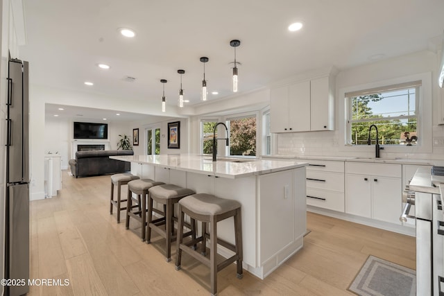 18 Rowena Rd, Manalapan, NJ 07726 - kitchen with freestanding refrigerator, light wood-type flooring, tasteful backsplash, open floor plan, and recessed lighting