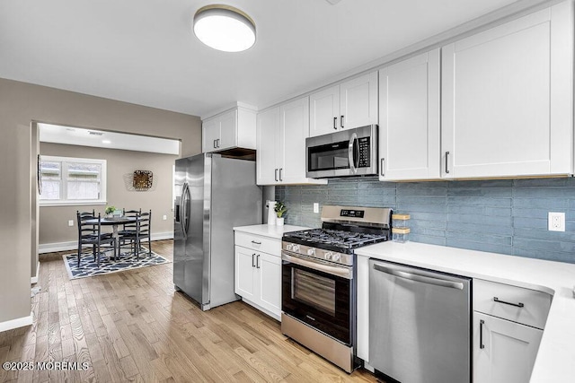 25 Montserrat St, Toms River, NJ 08757 - kitchen with appliances with stainless steel finishes, light countertops, white cabinetry, backsplash, and light wood-style floors