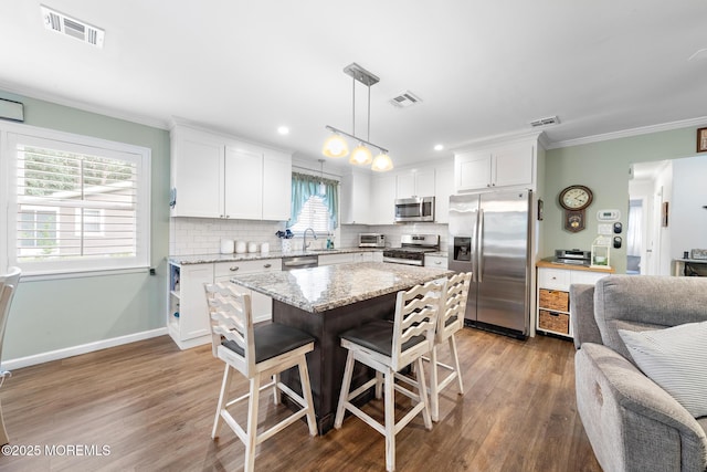 14 Campion Ct, Brick, NJ 08724 - kitchen with stainless steel appliances, wood finished floors, white cabinetry, decorative backsplash, and ornamental molding