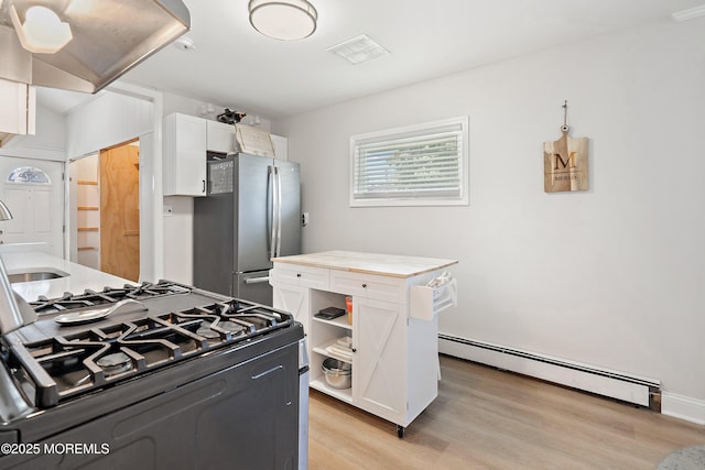 2905 Appleby Dr, Ocean Twp, NJ 07712 - kitchen featuring a baseboard heating unit, freestanding refrigerator, range with gas stovetop, and white cabinetry