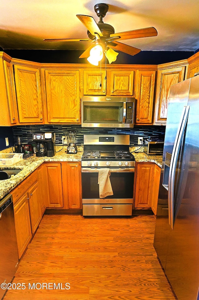 1509 Embury Ave, Neptune Township, NJ 07753 - kitchen with stainless steel appliances, tasteful backsplash, brown cabinetry, and a ceiling fan