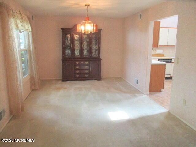 294 Marni Ln, Lakewood, NJ 08701 - unfurnished dining area featuring a chandelier and light carpet