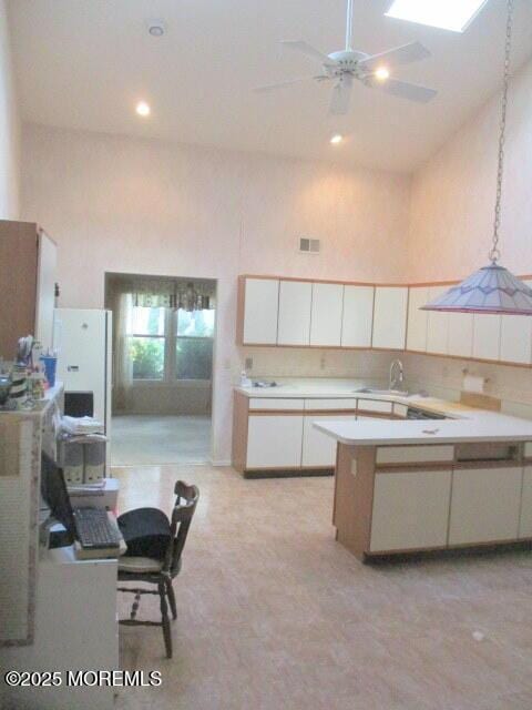 294 Marni Ln, Lakewood, NJ 08701 - kitchen with a towering ceiling, light countertops, ceiling fan, white cabinets, and a peninsula