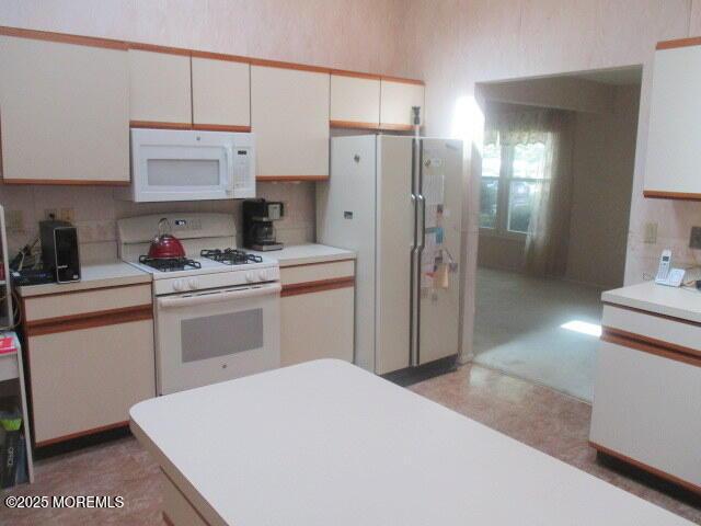 294 Marni Ln, Lakewood, NJ 08701 - kitchen featuring white appliances, white cabinets, light floors, light countertops, and tasteful backsplash