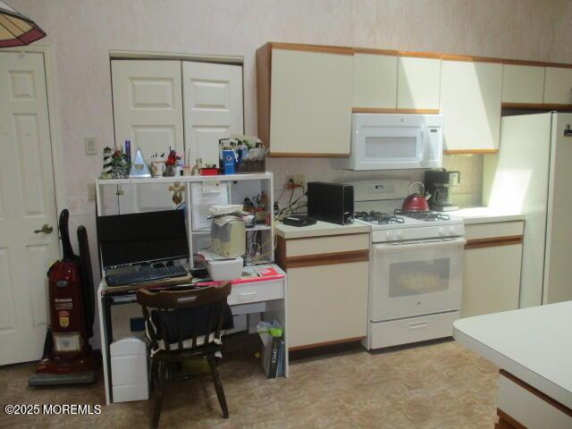 294 Marni Ln, Lakewood, NJ 08701 - kitchen with white appliances, light countertops, a desk, and white cabinetry