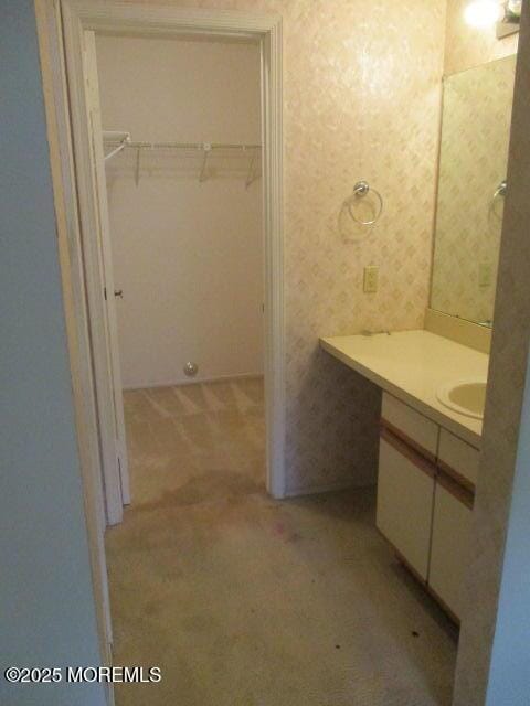 294 Marni Ln, Lakewood, NJ 08701 - bathroom featuring vanity, a walk in closet, and wallpapered walls