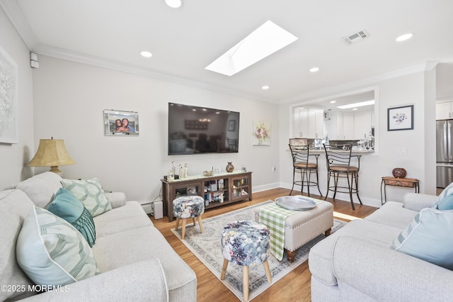 25 Tropicana Ct, Toms River, NJ 08757 - living room with a skylight, ornamental molding, recessed lighting, light wood-type flooring, and baseboard heating